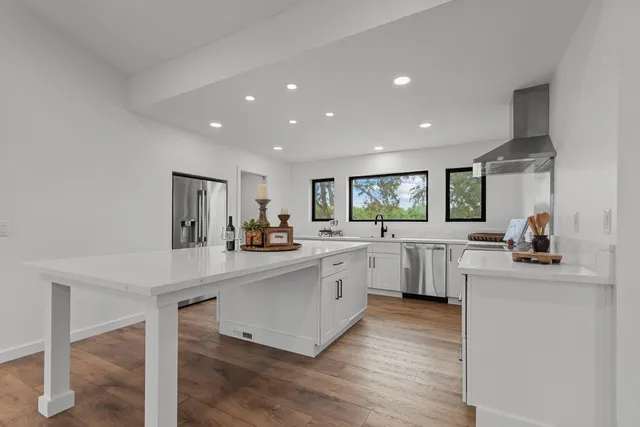 a kitchen with white cabinets and sink
