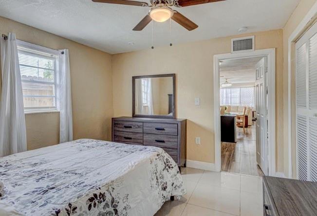 1105 West 34th Street Riviera Beach, FL 33404 - Photo 11 of 15 a bedroom with a bed and a chandelier