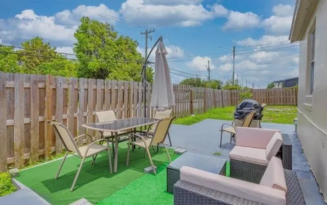 a view of a chairs and table in the back yard
