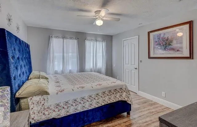 a bedroom with a large bed and a chandelier