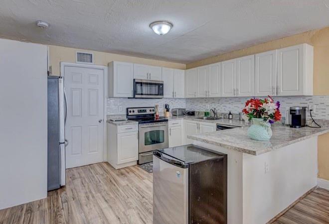 1105 West 34th Street Riviera Beach, FL 33404 - Photo 4 of 15 a kitchen with granite countertop a refrigerator stove and sink