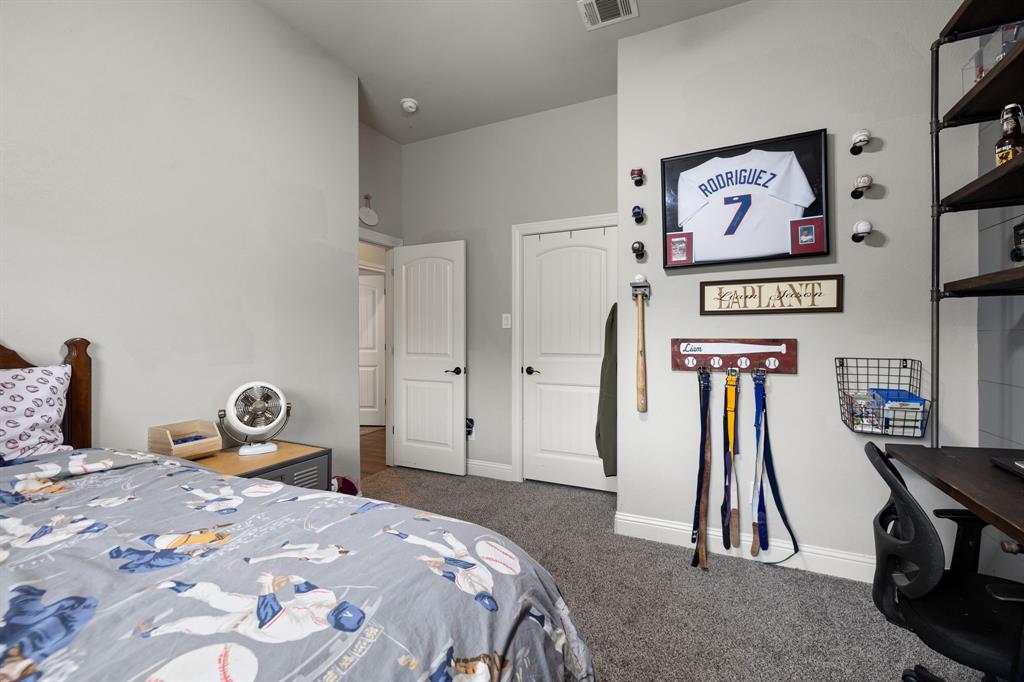2103 Cash Point Court Granbury, TX 76049 - Photo 21 of 38 a bedroom with a bed and a chandelier