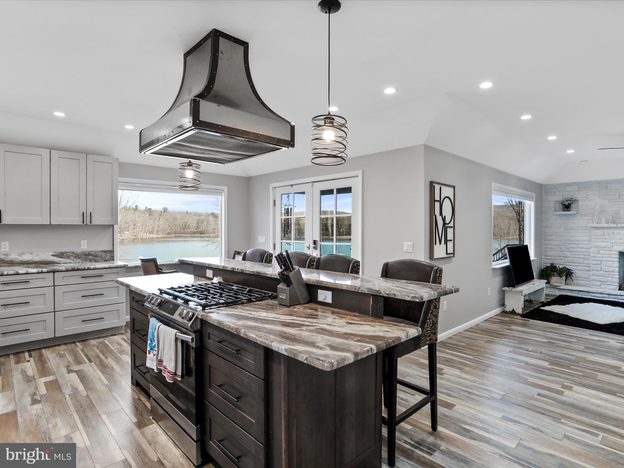 468 Pritts Road Swanton, MD 21561 - Photo 6 of 58 a kitchen with a stove a sink a kitchen island with wooden floor and cabinets