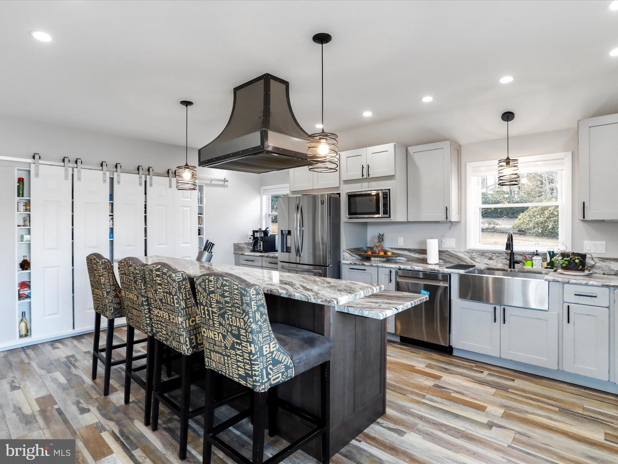 468 Pritts Road Swanton, MD 21561 - Photo 8 of 58 a kitchen with stainless steel appliances granite countertop a stove a sink dishwasher a dining table and chairs with wooden floor