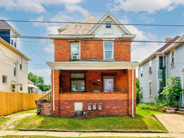 a view of a white house with large windows and a small yard