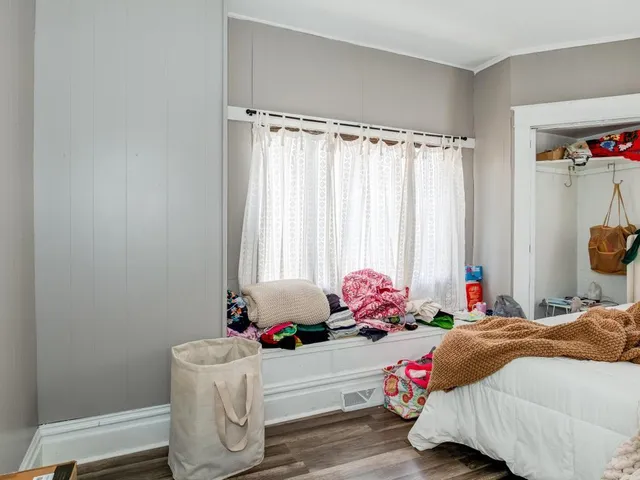 a bedroom with a bed and a window