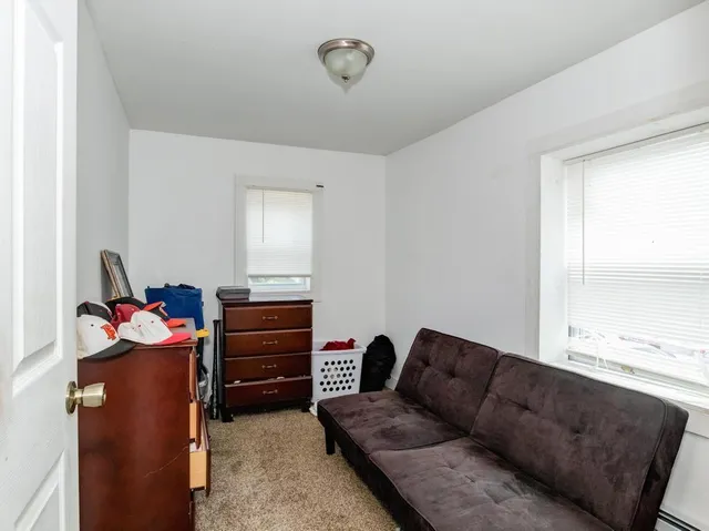 a living room with furniture a flat screen tv and a window
