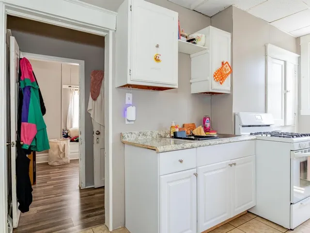 a kitchen with white cabinets and sink