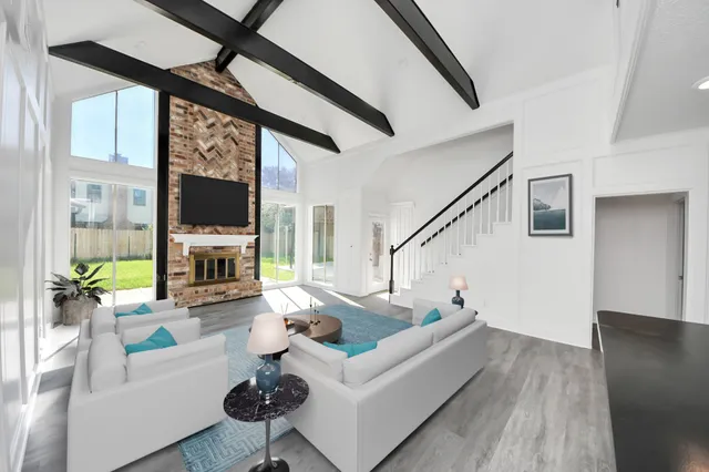 a living room with furniture a fireplace and a flat screen tv