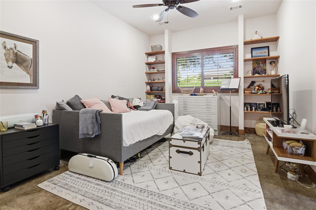 1138 Bancroft Road Keller, TX 76248 - Photo 25 of 39 Room featuring a ceiling fan, a window with plantation shutters, and built-in wood-finish shelving