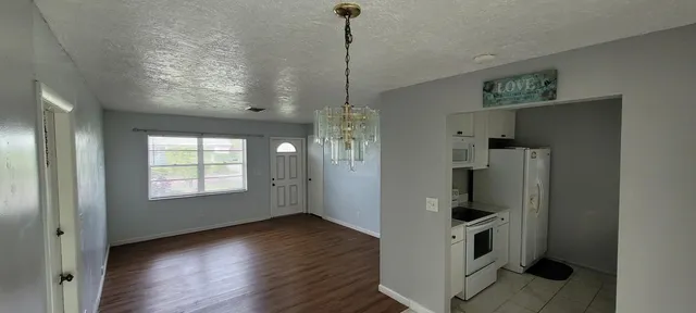 a view of kitchen and hallway with wooden floor