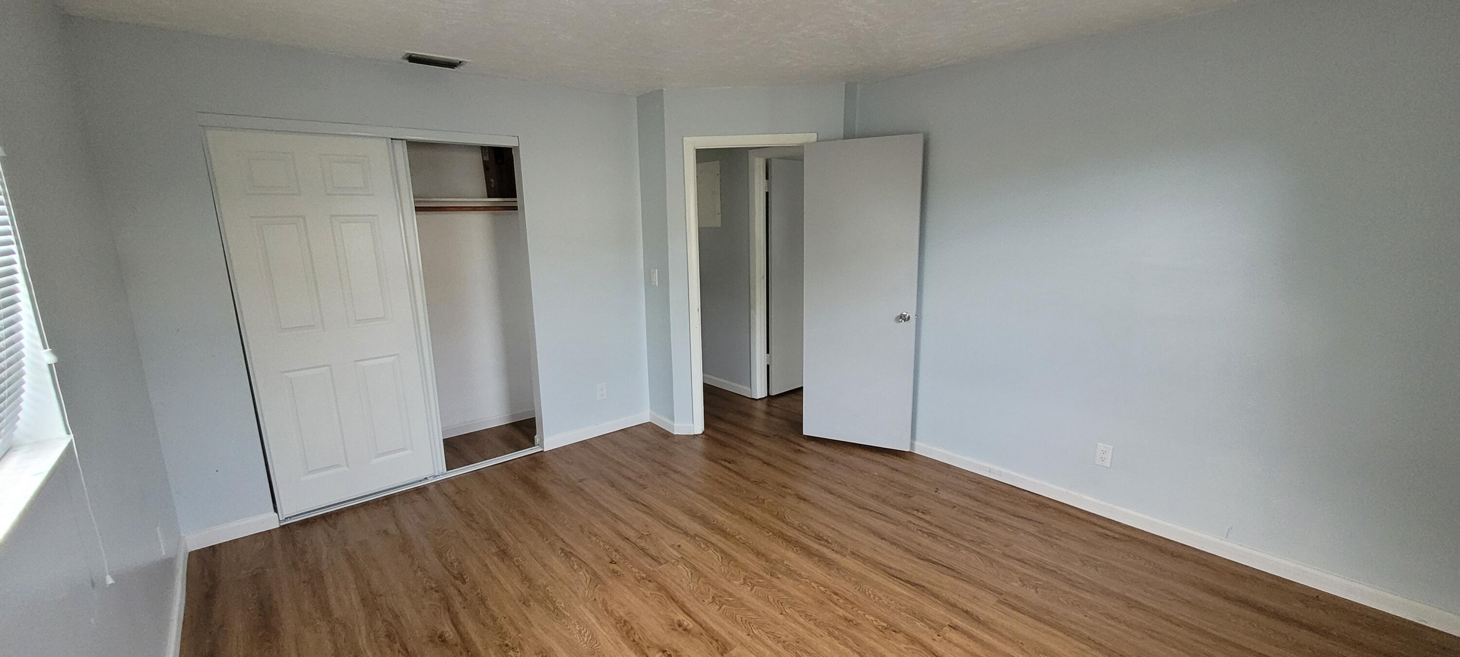 351 West 21st Street Riviera Beach, FL 33404 - Photo 8 of 11 a view of an empty room with wooden floor and a window