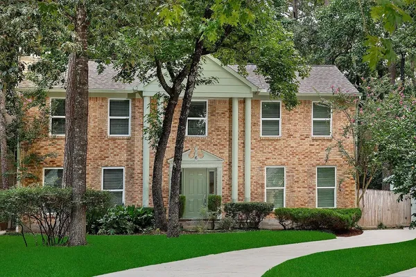 a front view of a house with a yard and trees