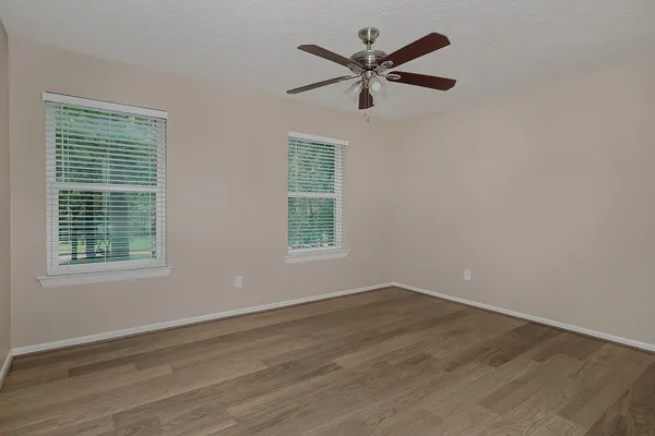 a view of a big room with wooden floor and windows