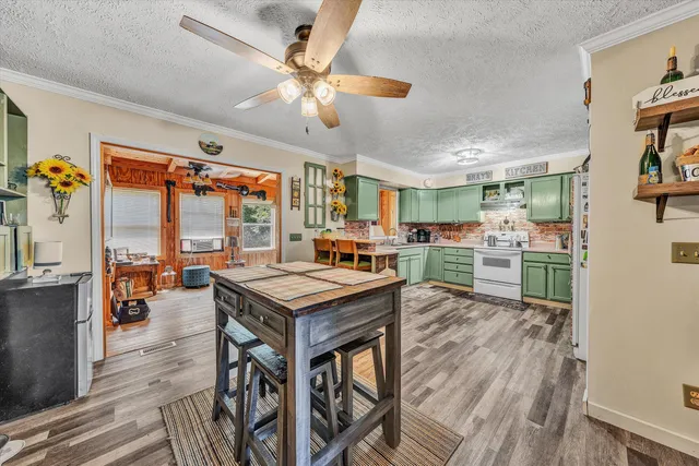 a room with stainless steel appliances a table chairs and a view of kitchen
