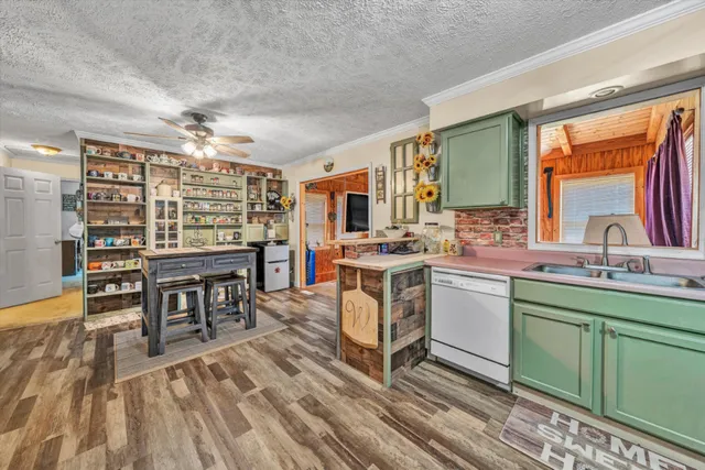 a open kitchen with stainless steel appliances granite countertop a stove top oven a sink dishwasher and cabinets with wooden floor