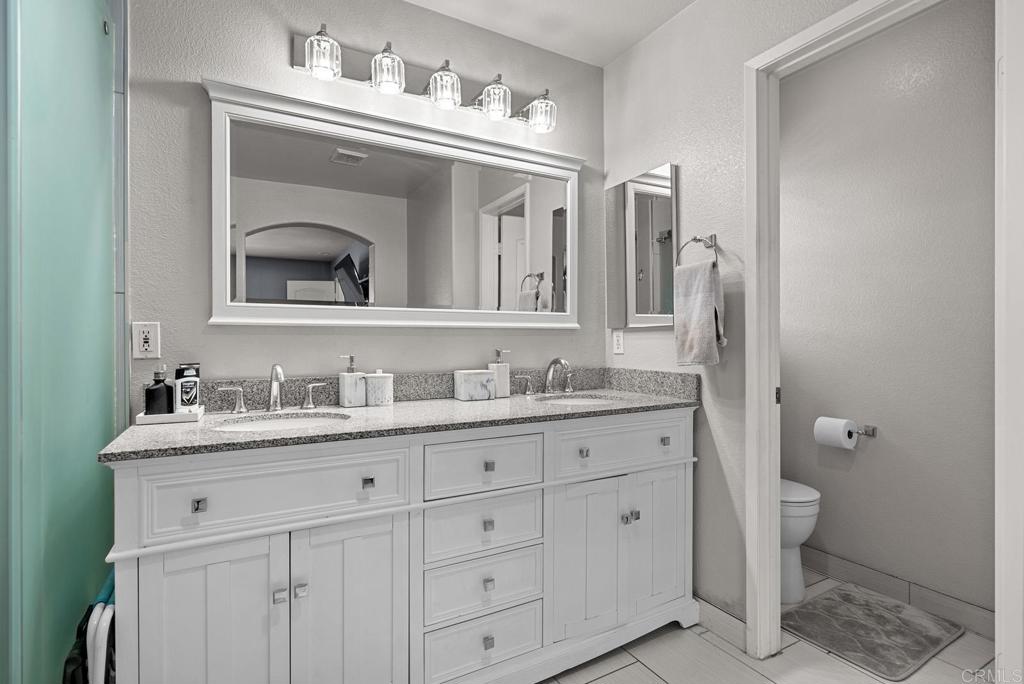 832 Laffey Lane El Cajon, CA 92021 - Photo 26 of 47 a en suite bathroom with a granite countertop sink and a mirror