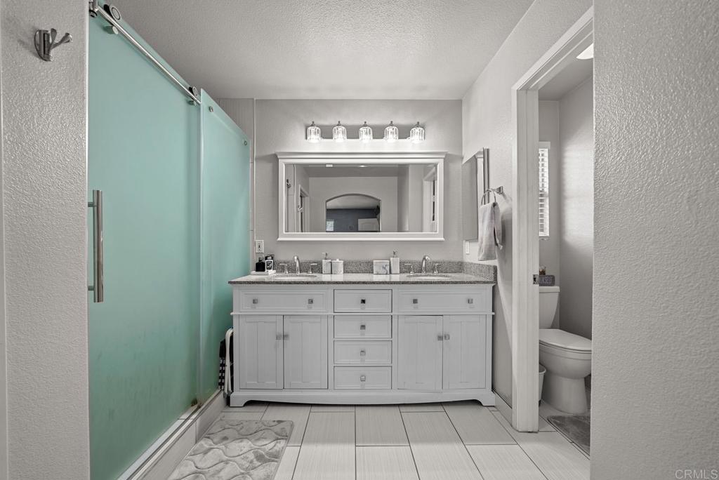 832 Laffey Lane El Cajon, CA 92021 - Photo 27 of 47 a bathroom with a granite countertop sink a mirror and a toilet