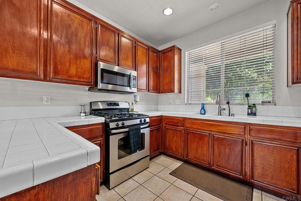 832 Laffey Lane El Cajon, CA 92021 - Photo 7 of 47 a kitchen with stainless steel appliances granite countertop wooden cabinets a stove top oven a sink and dishwasher