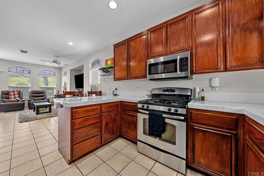 832 Laffey Lane El Cajon, CA 92021 - Photo 8 of 47 a kitchen with stainless steel appliances granite countertop a stove top oven a sink dishwasher and cabinets with wooden floor