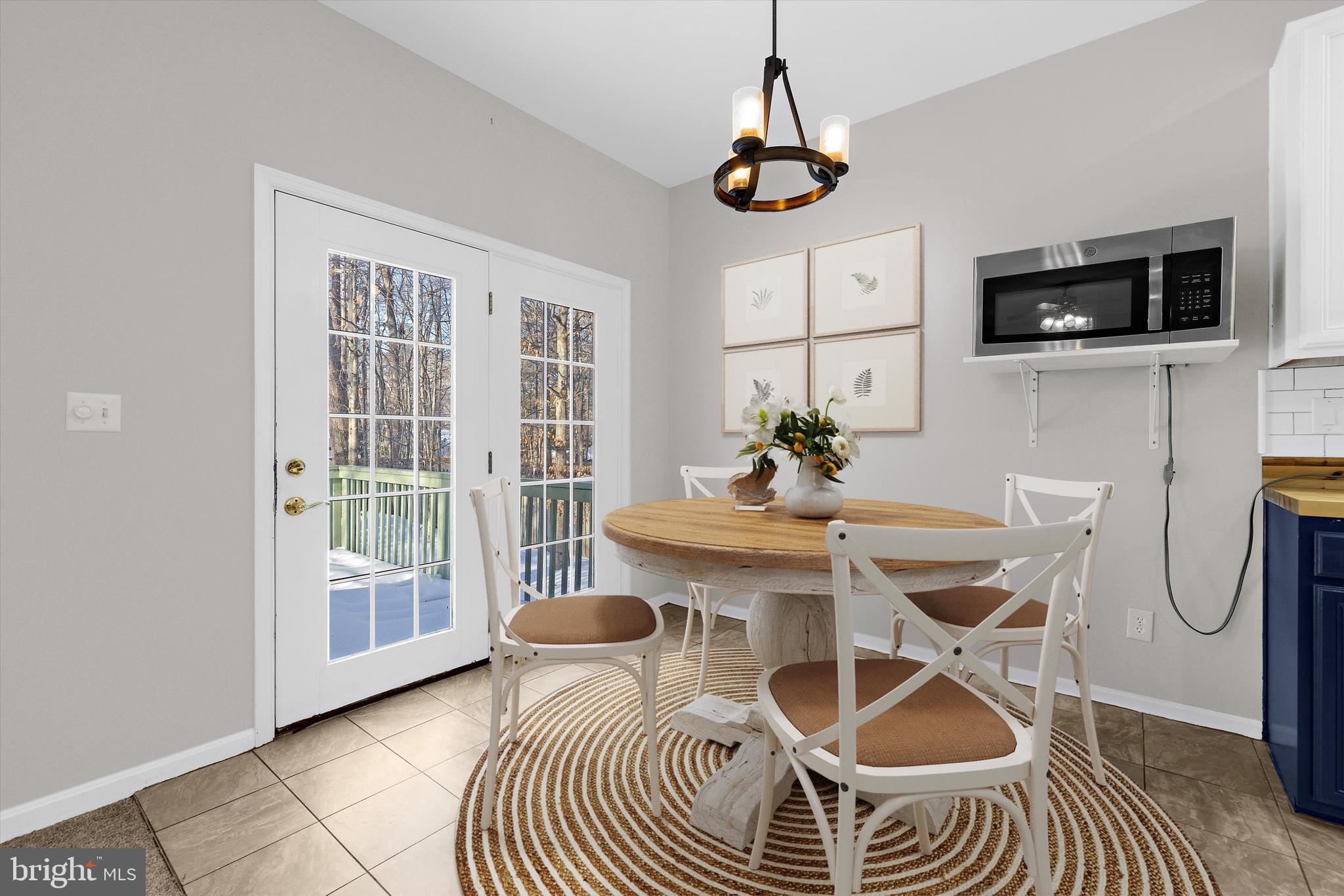 7144 Fir Street Easton, MD 21601 - Photo 6 of 24 a dining room with furniture a rug a potted plant and windows