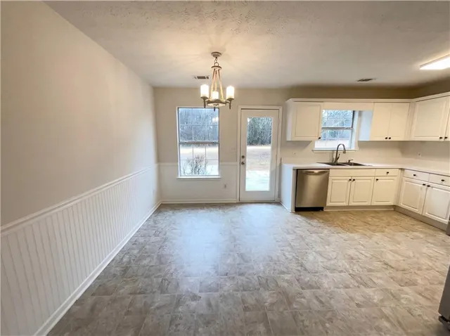 an empty room with chandelier and windows