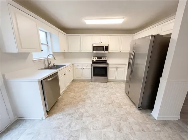 a kitchen with stainless steel appliances white cabinets and a refrigerator