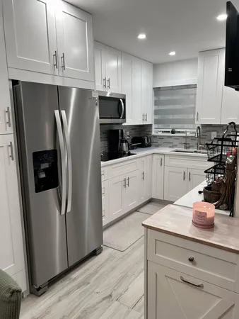 a kitchen with stainless steel appliances a refrigerator sink and microwave