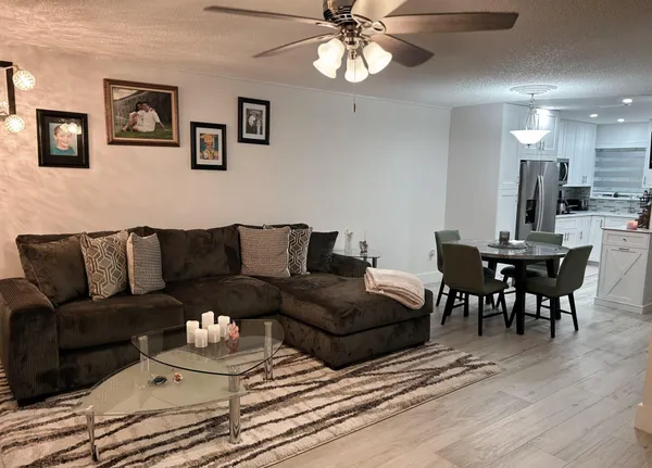 a living room with furniture kitchen and a chandelier