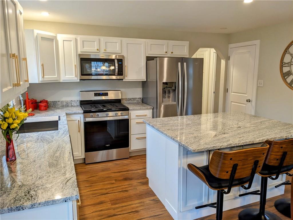 432 Raspberry Drive Monroeville, PA 15146 - Photo 11 of 39 a kitchen with granite countertop wooden floor cabinets and stainless steel appliances