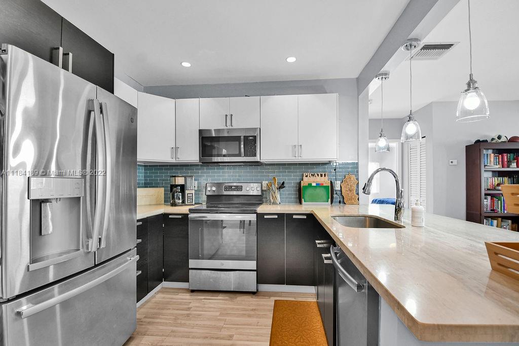 331 Northwest 144th Street Miami, FL 33168 - Photo 20 of 35 a kitchen with stainless steel appliances granite countertop a refrigerator a sink and a stove