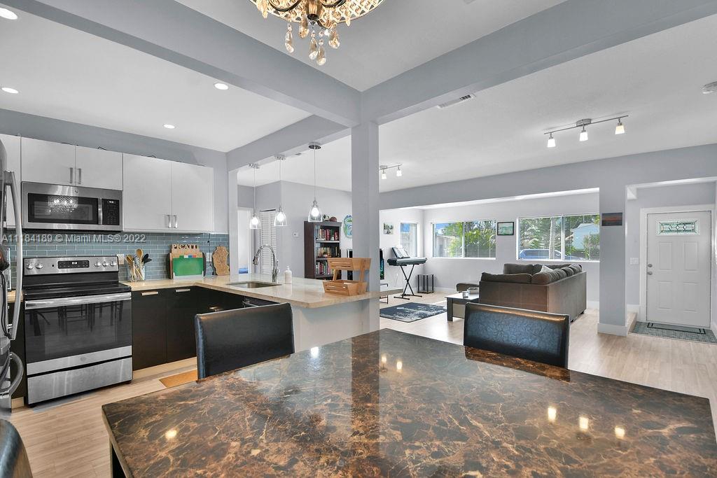 331 Northwest 144th Street Miami, FL 33168 - Photo 21 of 35 a large open kitchen with a large window a stove and a refrigerator