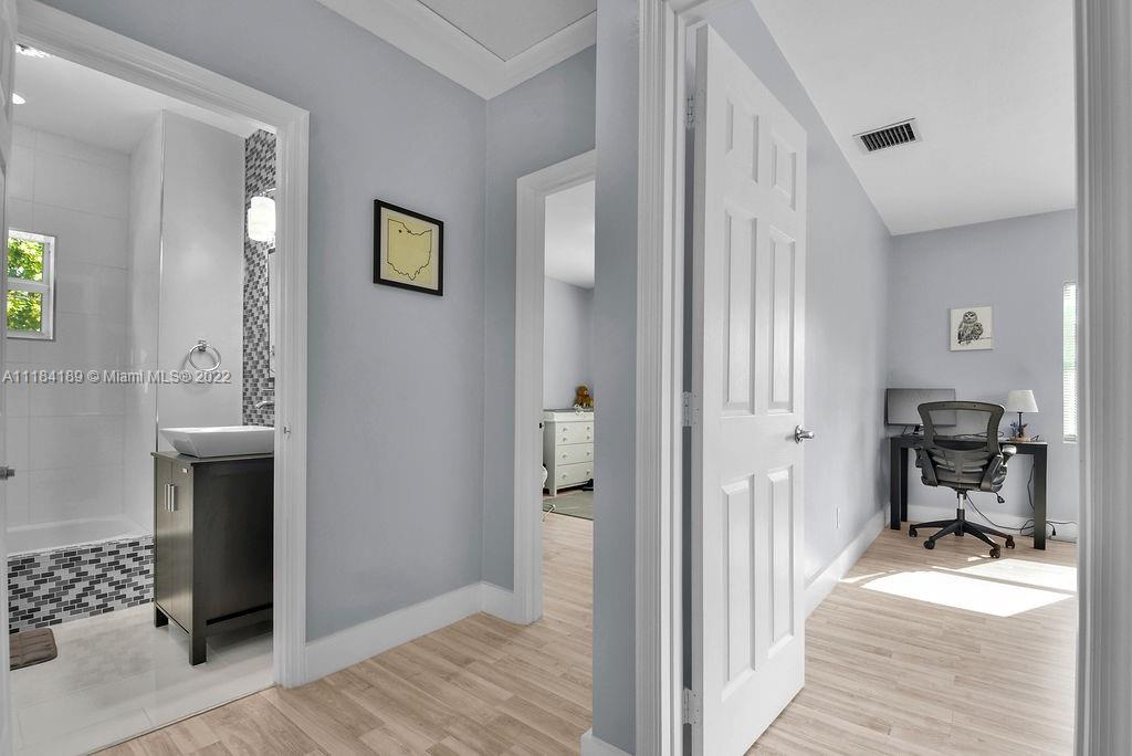 331 Northwest 144th Street Miami, FL 33168 - Photo 26 of 35 a view of a hallway with bathroom and wooden floor