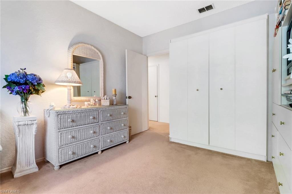 110 Siena Way, Unit 206 Naples, FL 34119 - Photo 16 of 35 a room with a dresser and a mirror