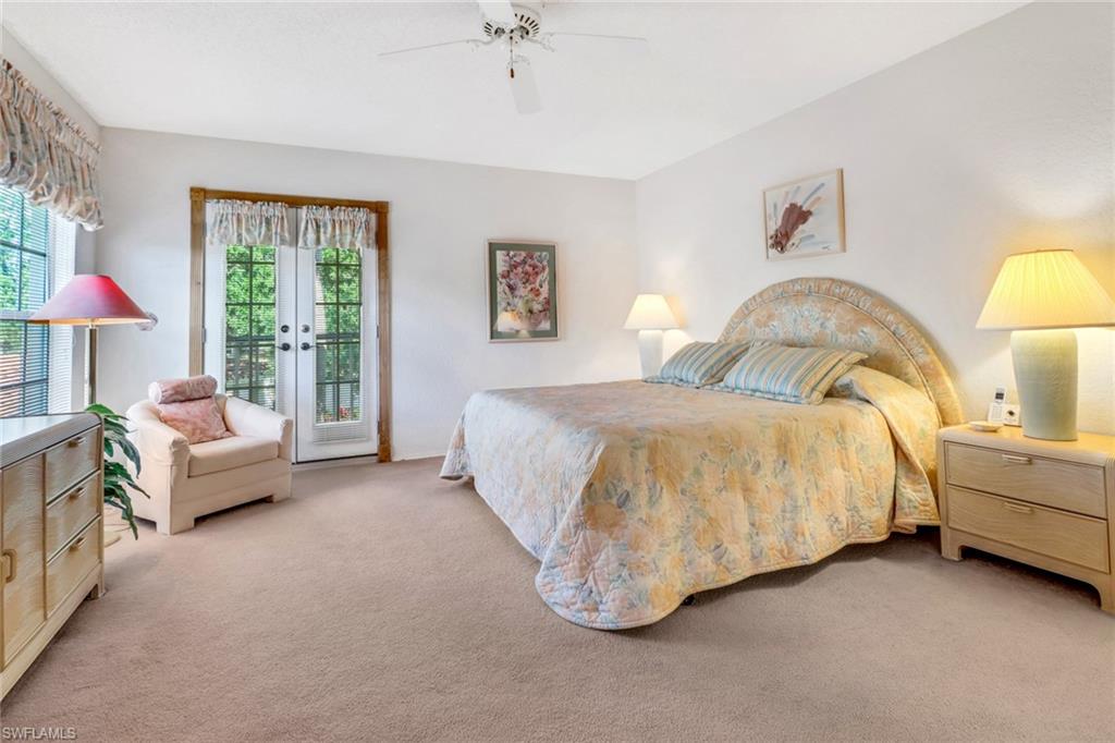 110 Siena Way, Unit 206 Naples, FL 34119 - Photo 18 of 35 a spacious bedroom with a bed and a couch