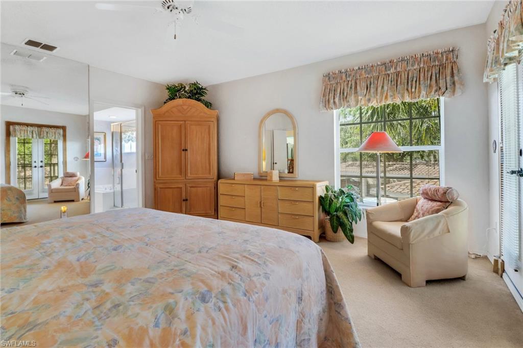 110 Siena Way, Unit 206 Naples, FL 34119 - Photo 19 of 35 a bedroom with a balcony a bed and a chandelier