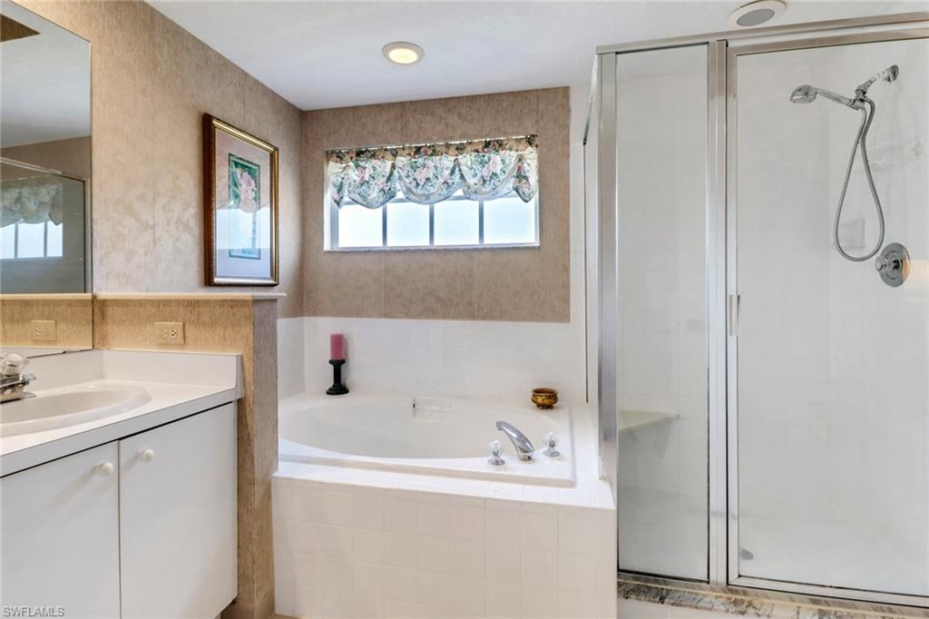 110 Siena Way, Unit 206 Naples, FL 34119 - Photo 21 of 35 a bathroom with a tub a sink and a window