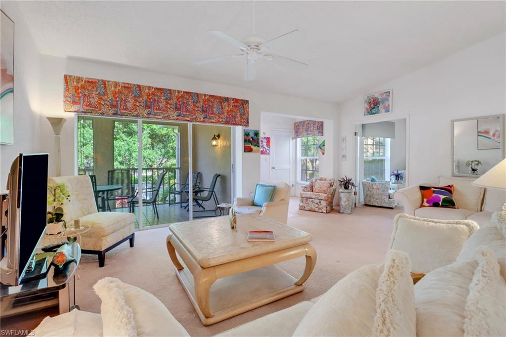 110 Siena Way, Unit 206 Naples, FL 34119 - Photo 8 of 35 a living room with furniture a flat screen tv and a floor to ceiling window