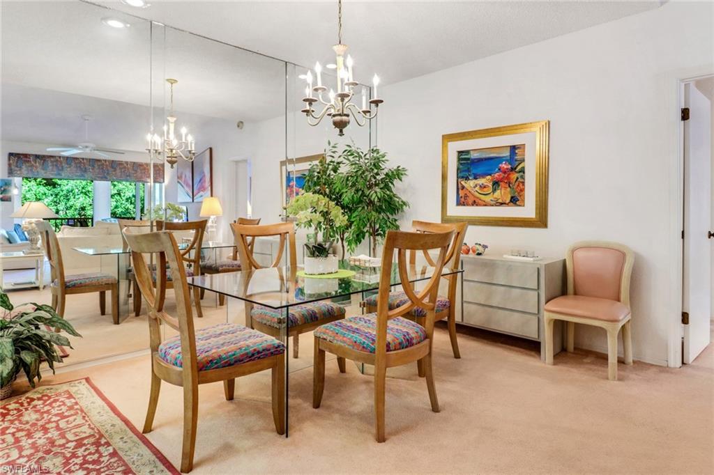 110 Siena Way, Unit 206 Naples, FL 34119 - Photo 9 of 35 a view of a dining room with furniture and chandelier