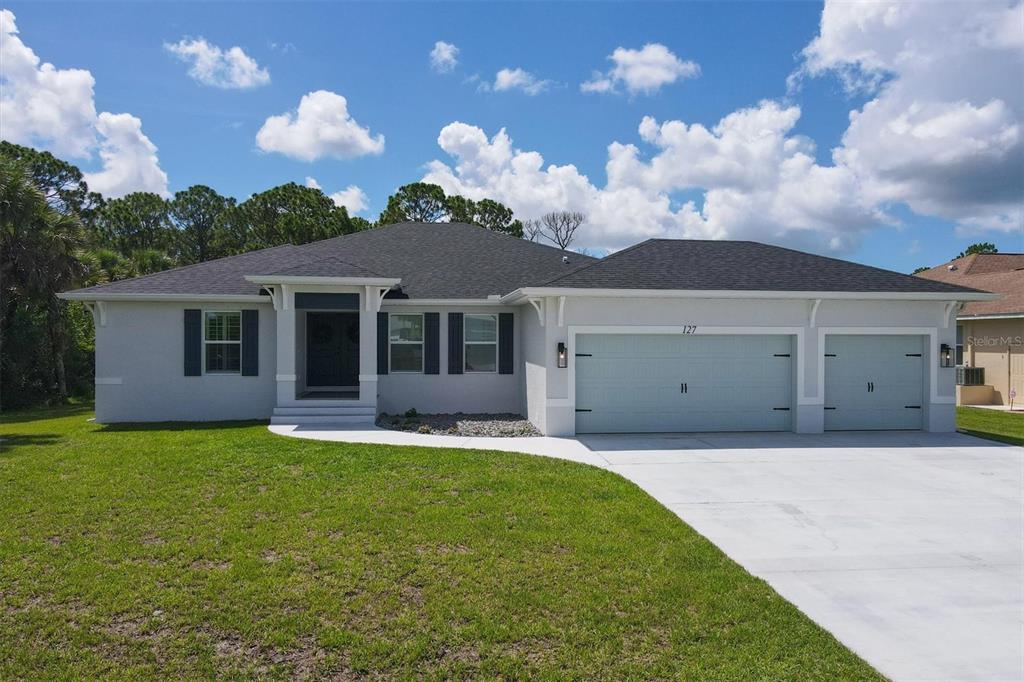 127 Hunter Road Rotonda West, FL 33947 - Photo 1 of 1 a front view of a house with a garden and yard