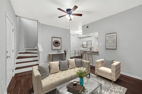 a living room with furniture and a ceiling fan