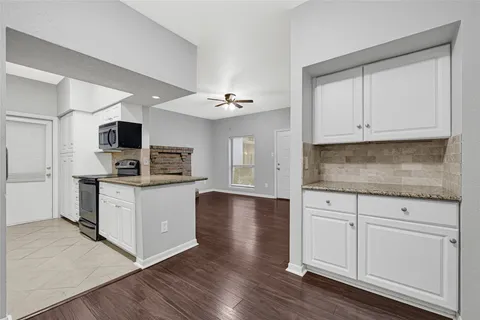 a kitchen with stainless steel appliances granite countertop a sink dishwasher stove and microwave with wooden cabinets