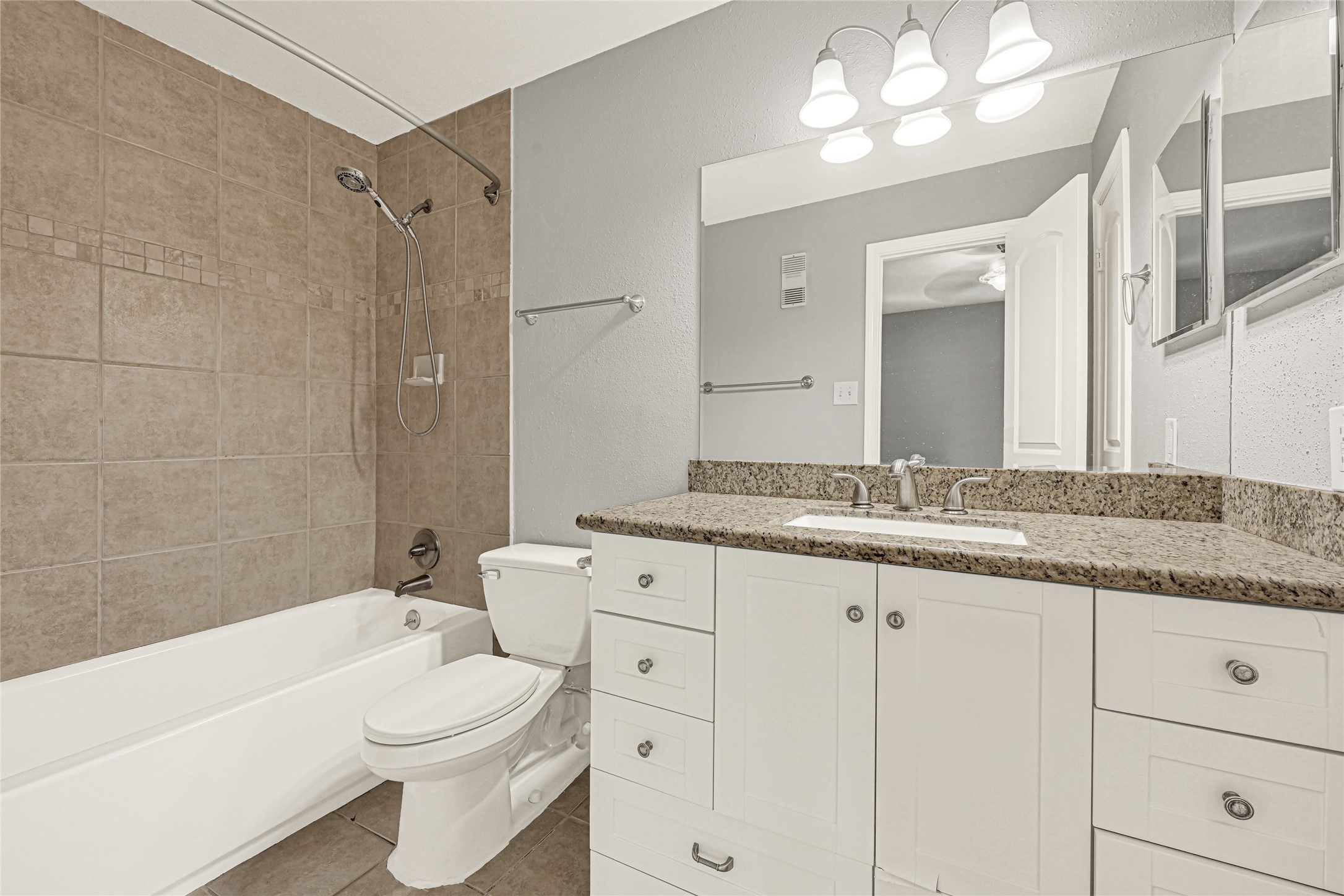 2425 Augusta Drive, Unit 29 Houston, TX 77057 - Photo 17 of 23 a bathroom with a granite countertop toilet a sink and bathtub