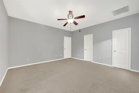 an empty room with a window and a ceiling fan