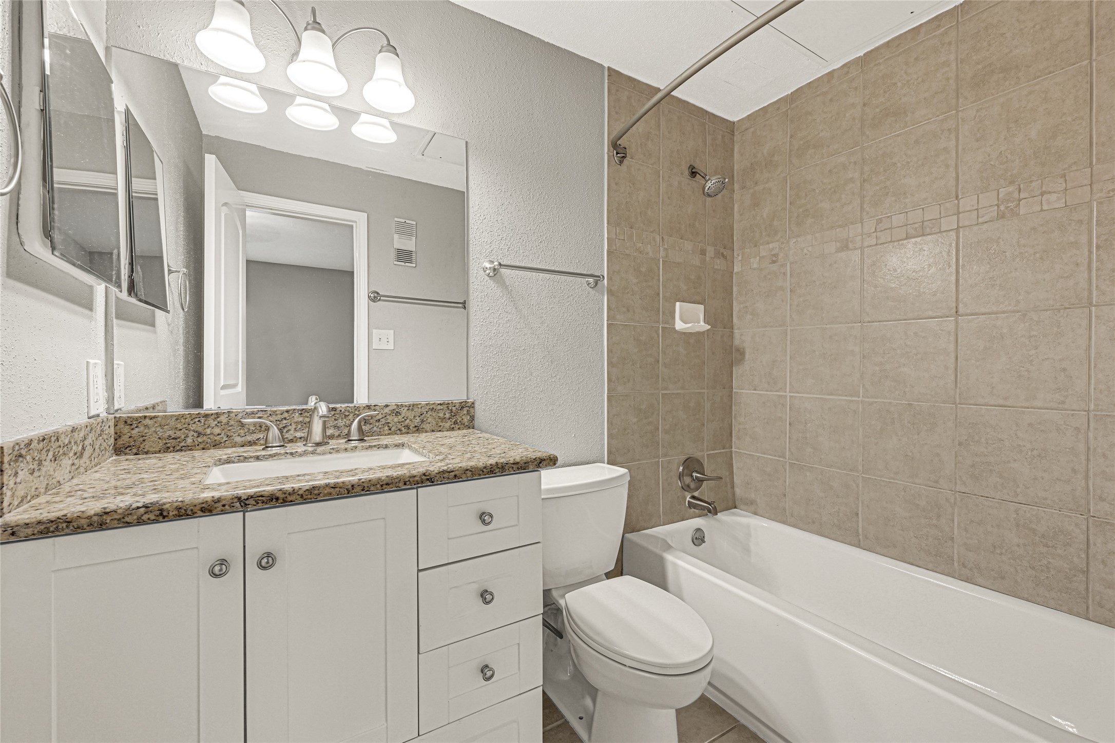 2425 Augusta Drive, Unit 29 Houston, TX 77057 - Photo 26 of 30 a bathroom with a granite countertop sink a toilet and bathtub