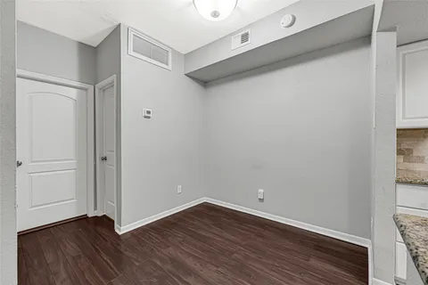 a kitchen with granite countertop a sink stainless steel appliances and white cabinets