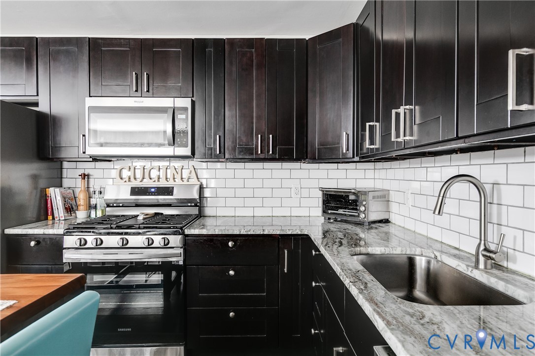 2815 Caniff Road Richmond, VA 23223 - Photo 11 of 39 a kitchen with a stove a sink and a microwave
