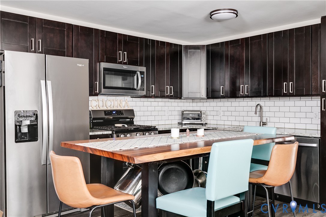 2815 Caniff Road Richmond, VA 23223 - Photo 13 of 39 a kitchen with a stove a refrigerator and a sink with wooden cabinets