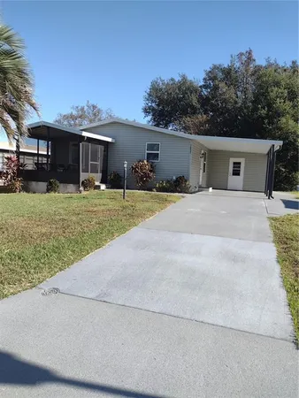 a front view of house with yard and trees in the background