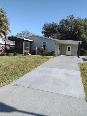 a front view of house with yard and trees in the background